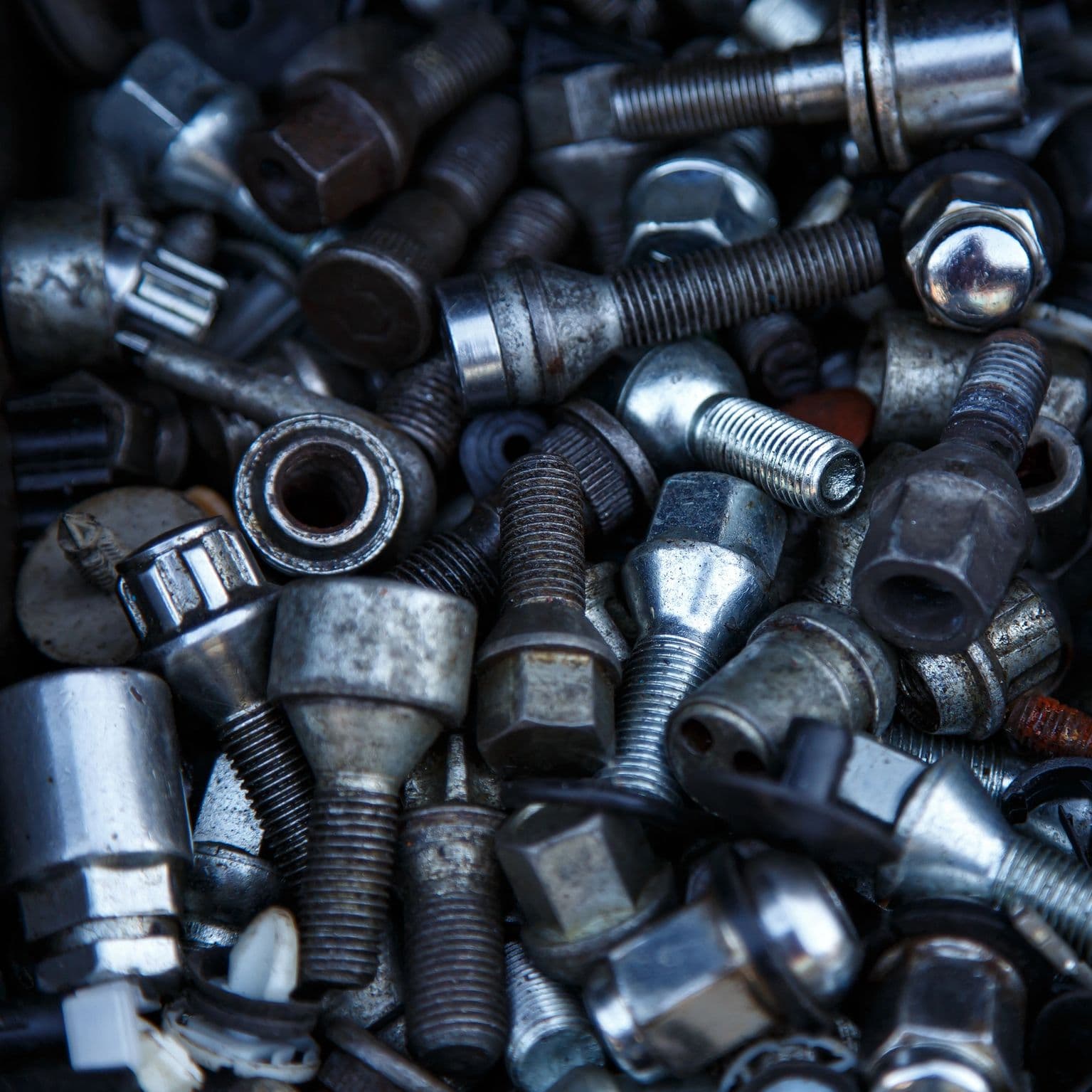 Industrial hardware pile of lug bolts, nuts, and fasteners